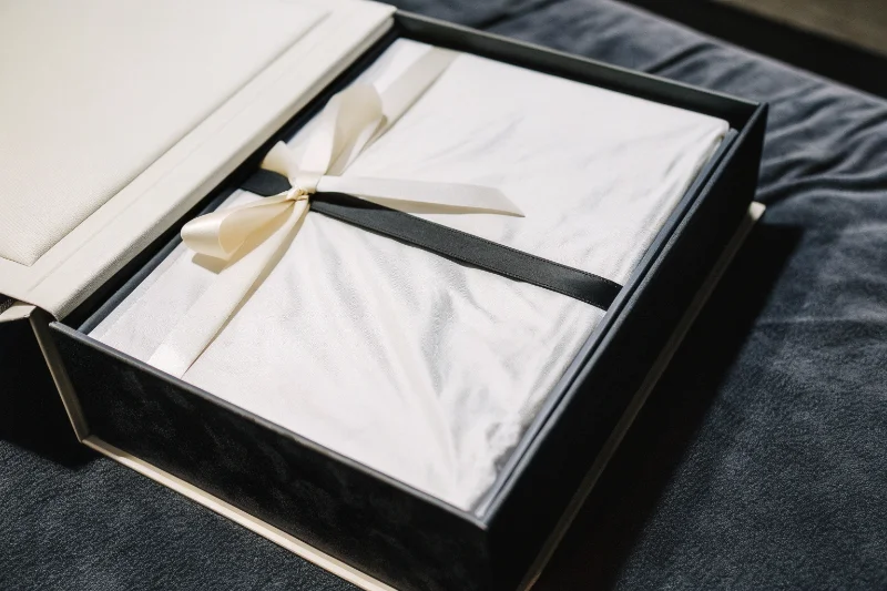 A close-up of a high-quality gift box with a ribbon for a photo album