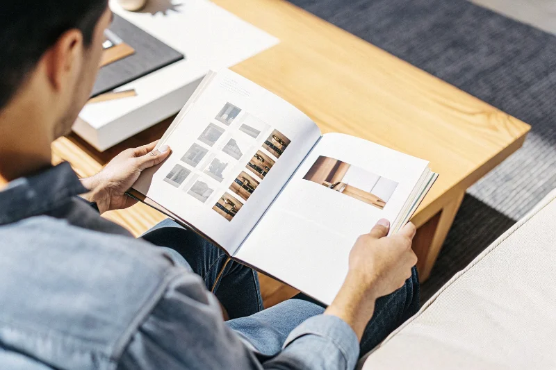Stylish person flipping through a coffee table album in a modern home