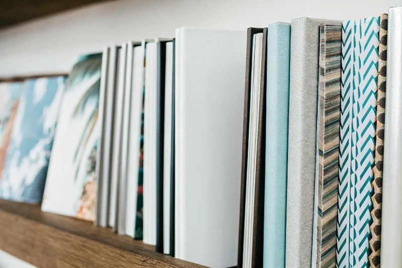 A classic linen photo album next to a modern one with a vibrant print