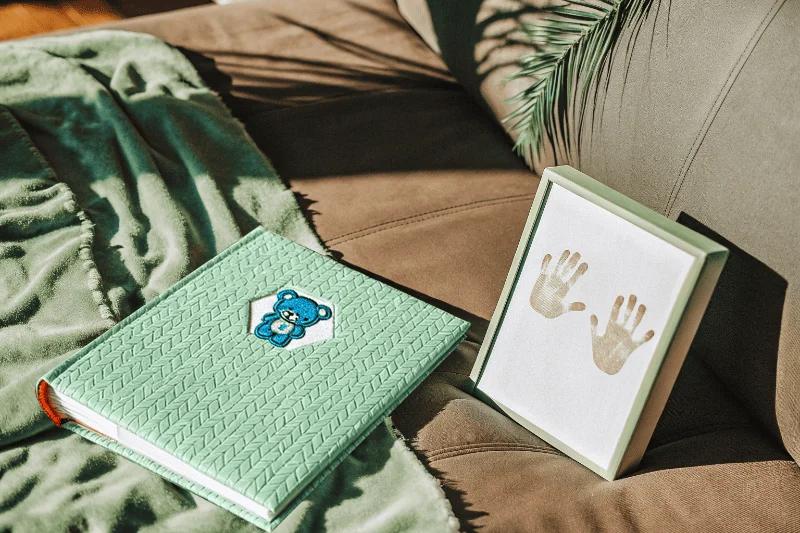 A baby handprint kit included with a baby album on a soft blanket
