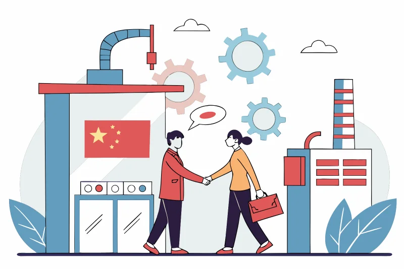 Two business people shaking hands in a factory setting, showing a partnership