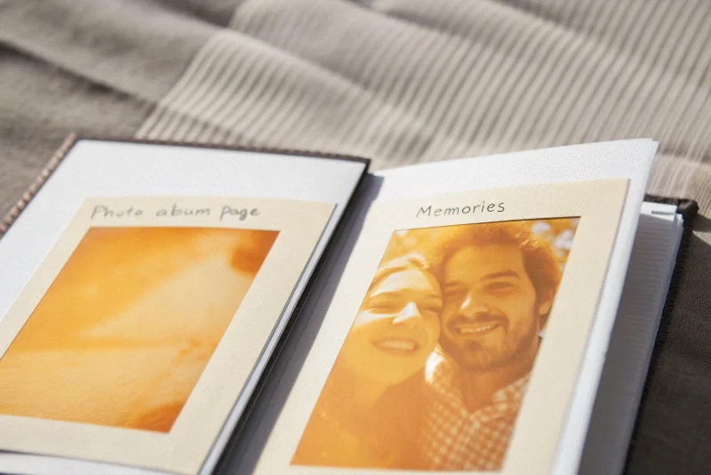 A slightly blurry, happy selfie of a couple inside a photo album page with handwritten notes