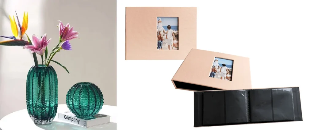 Beige family photo album with cover photo, open album with black pages displayed, next to green textured glass vases on a white table.